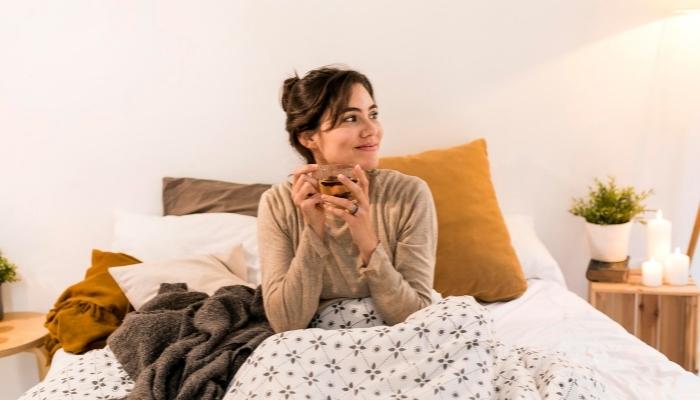 Woman drinking soothing tea in bed