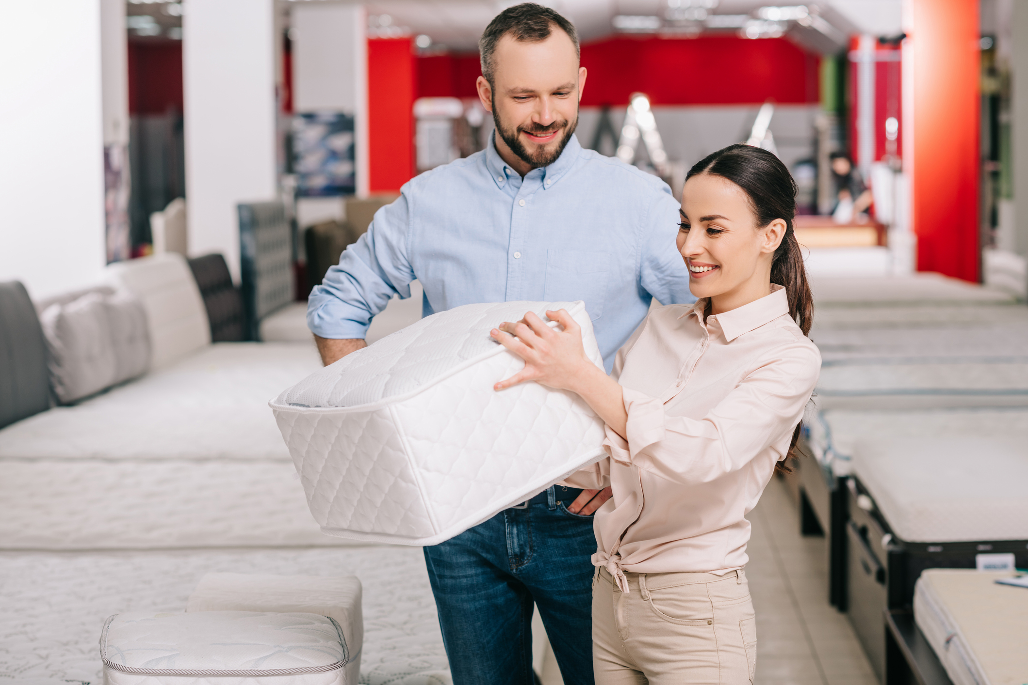 salesperson and customer testing mattress sample