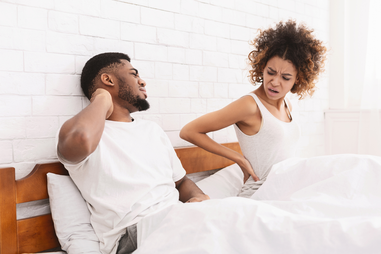 young couple showing discomfort from sleeping on mattress