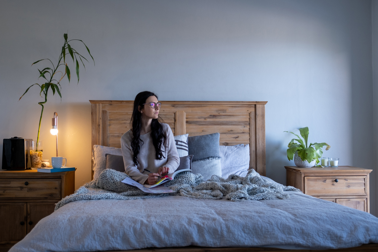 Woman studies in her functional and furnished bedroom