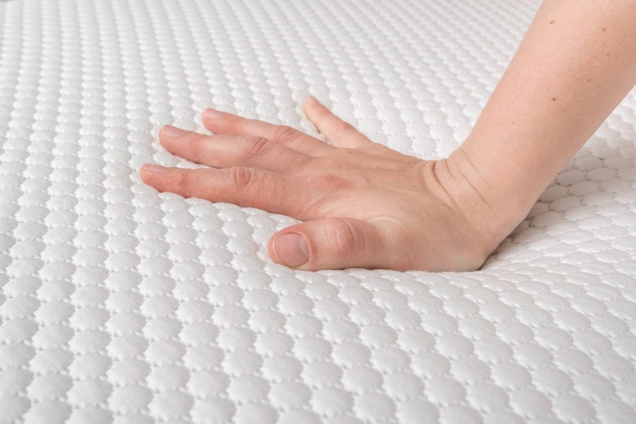 hand of woman is testing mattress quality