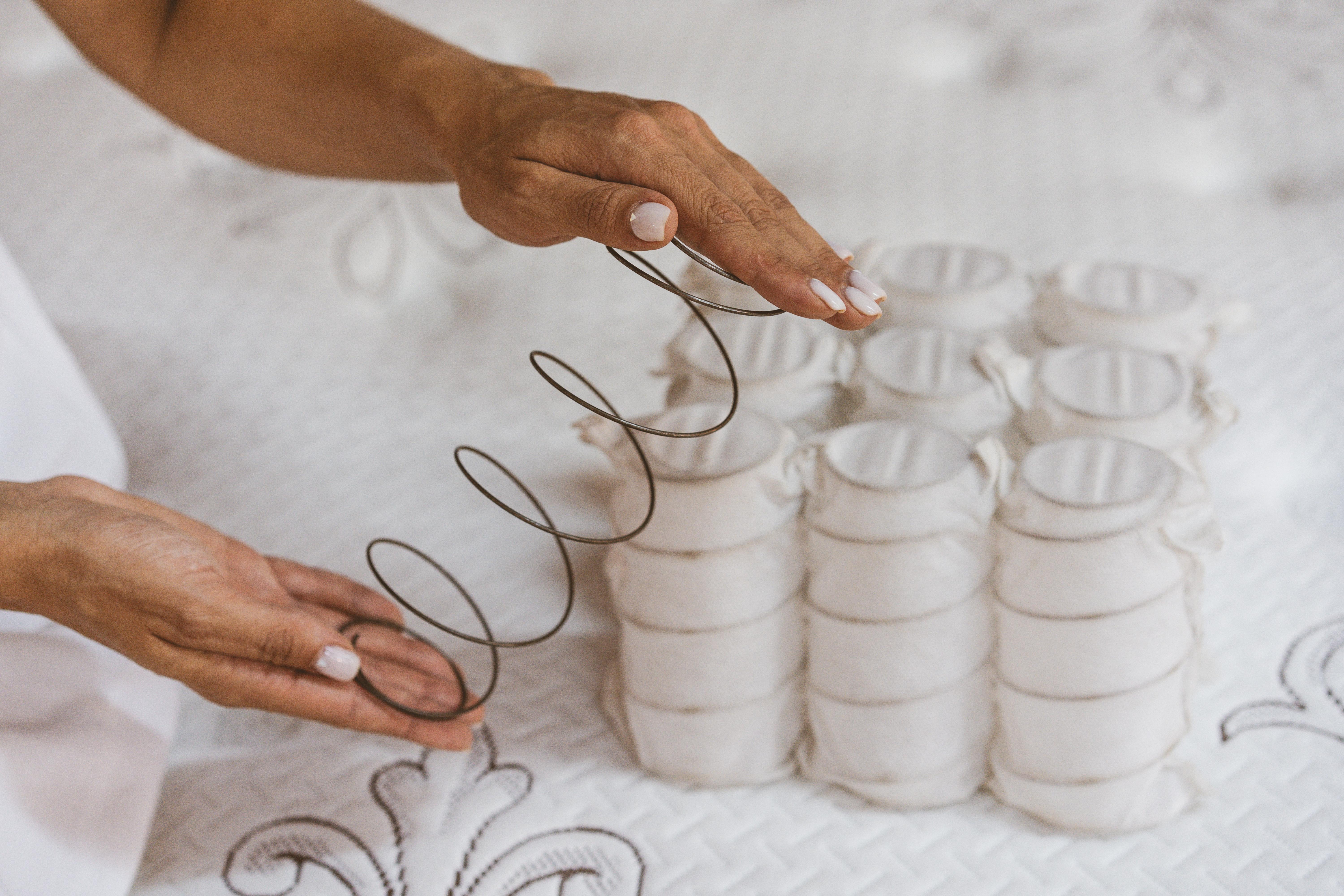 Woman holding a mattress coil with pocketed coils in the background