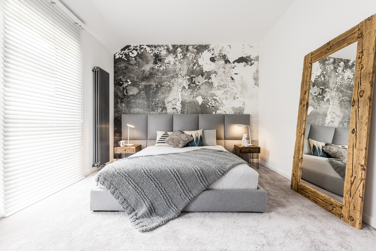 gray-themed bedroom with large mirror framed with reclaimed wood