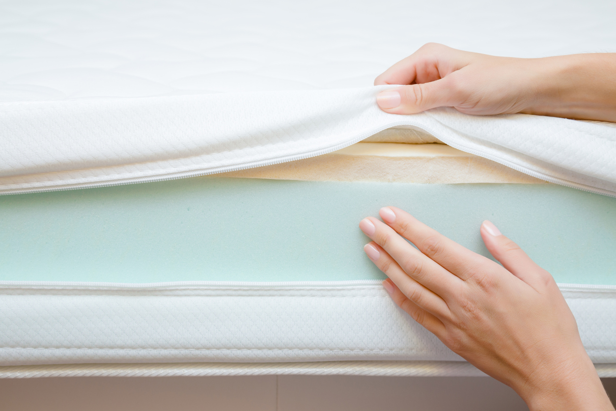 woman's hands touching different layers of new mattress