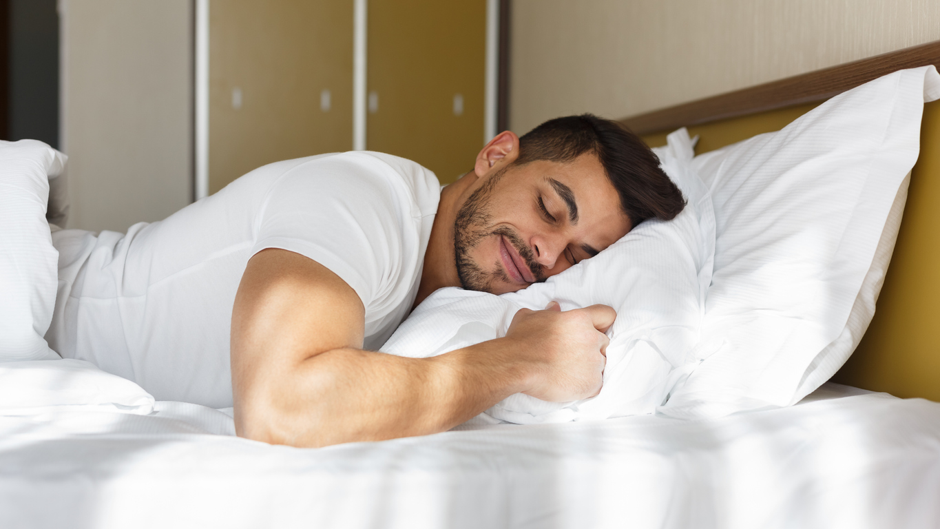 Man sleeps on his side in bed