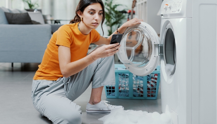 Woman contacting service people for leaking washer