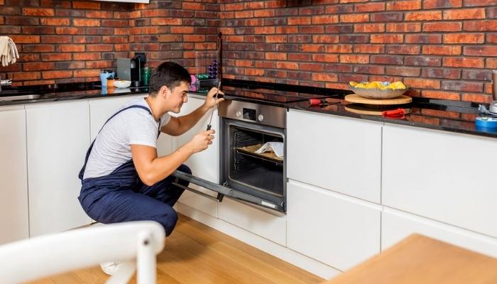 repairman with tools near oven