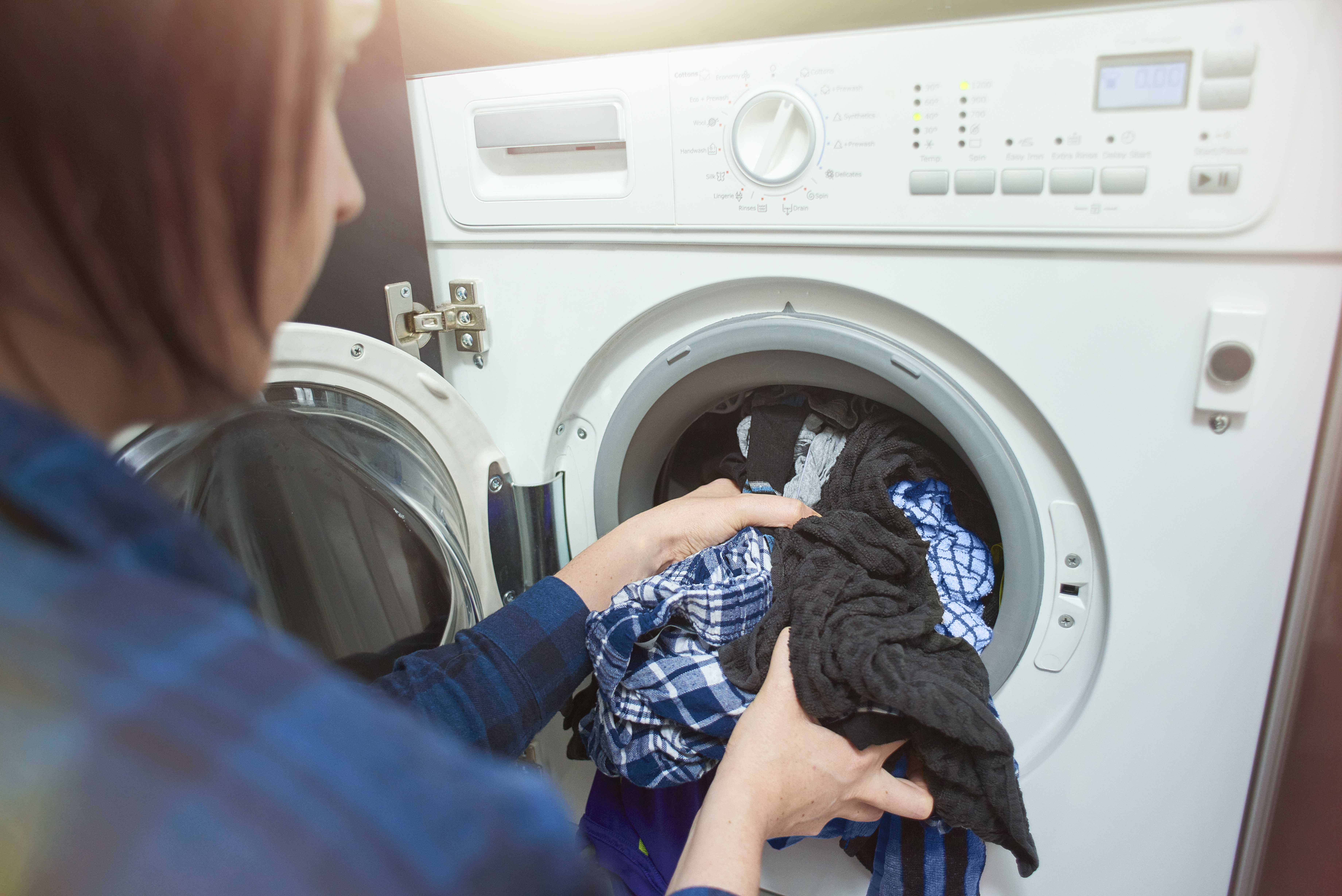 Woman unloads clothes from front load washer