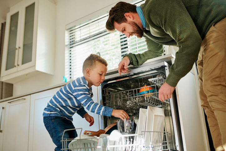 Father and son loading dishwasher together