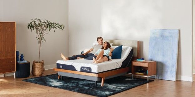 Woman and man relax on their iComfort by Serta mattress and adjustable power base