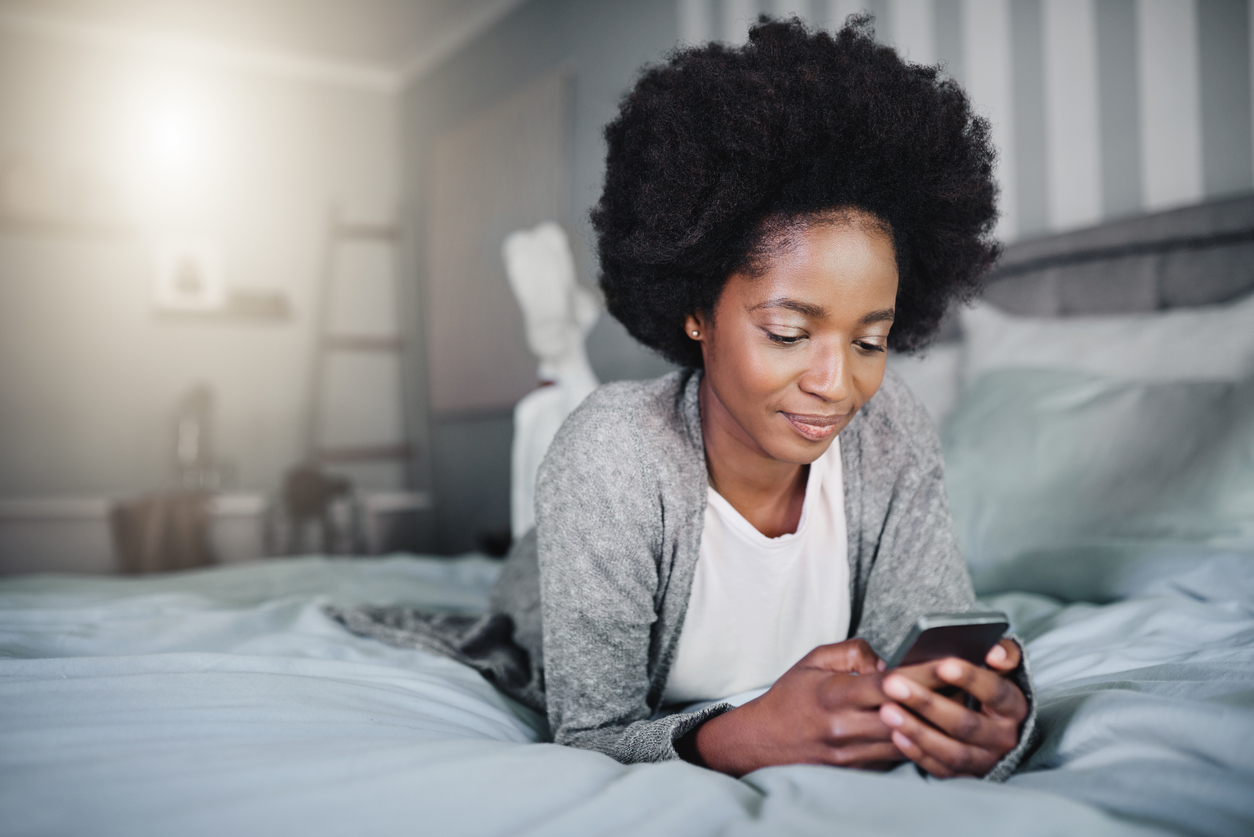 a woman looking at her phone on the bed