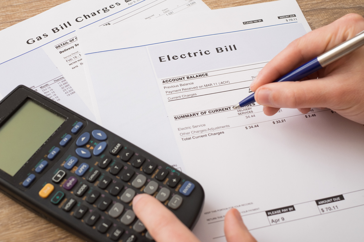 person assessing electric bill expenses with calculator