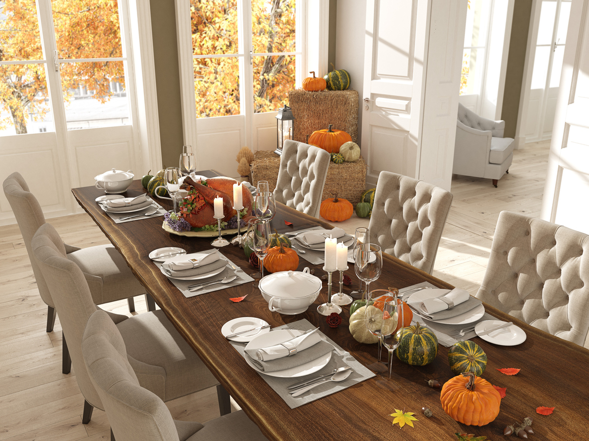 An elegant dining room fully set and decorated with fall decor