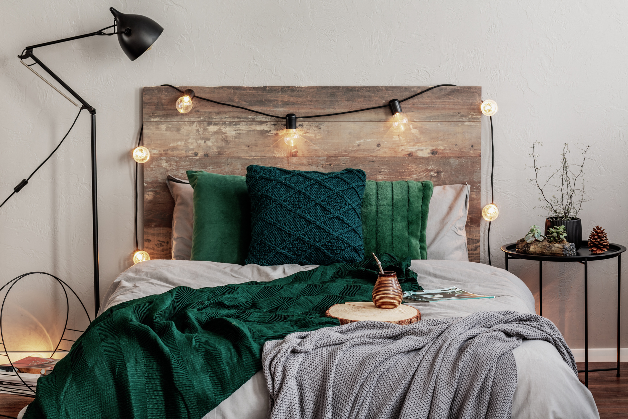 green bedding and wooden headboard in bedroom