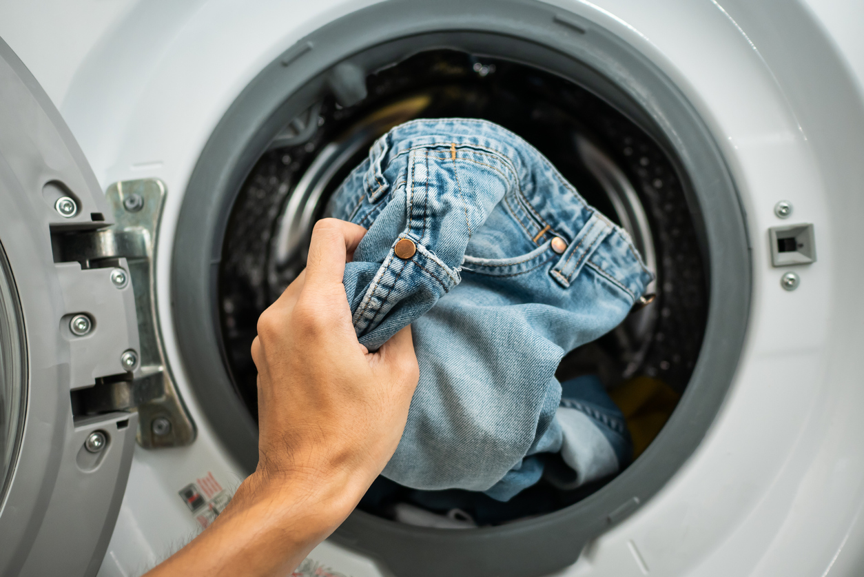 Jeans being put in front-load dryer