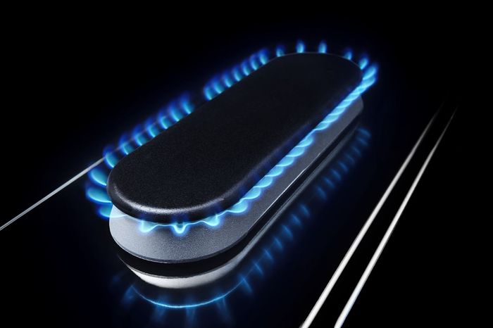 Maytag's oval-shaped range burner, lit with blue flames.