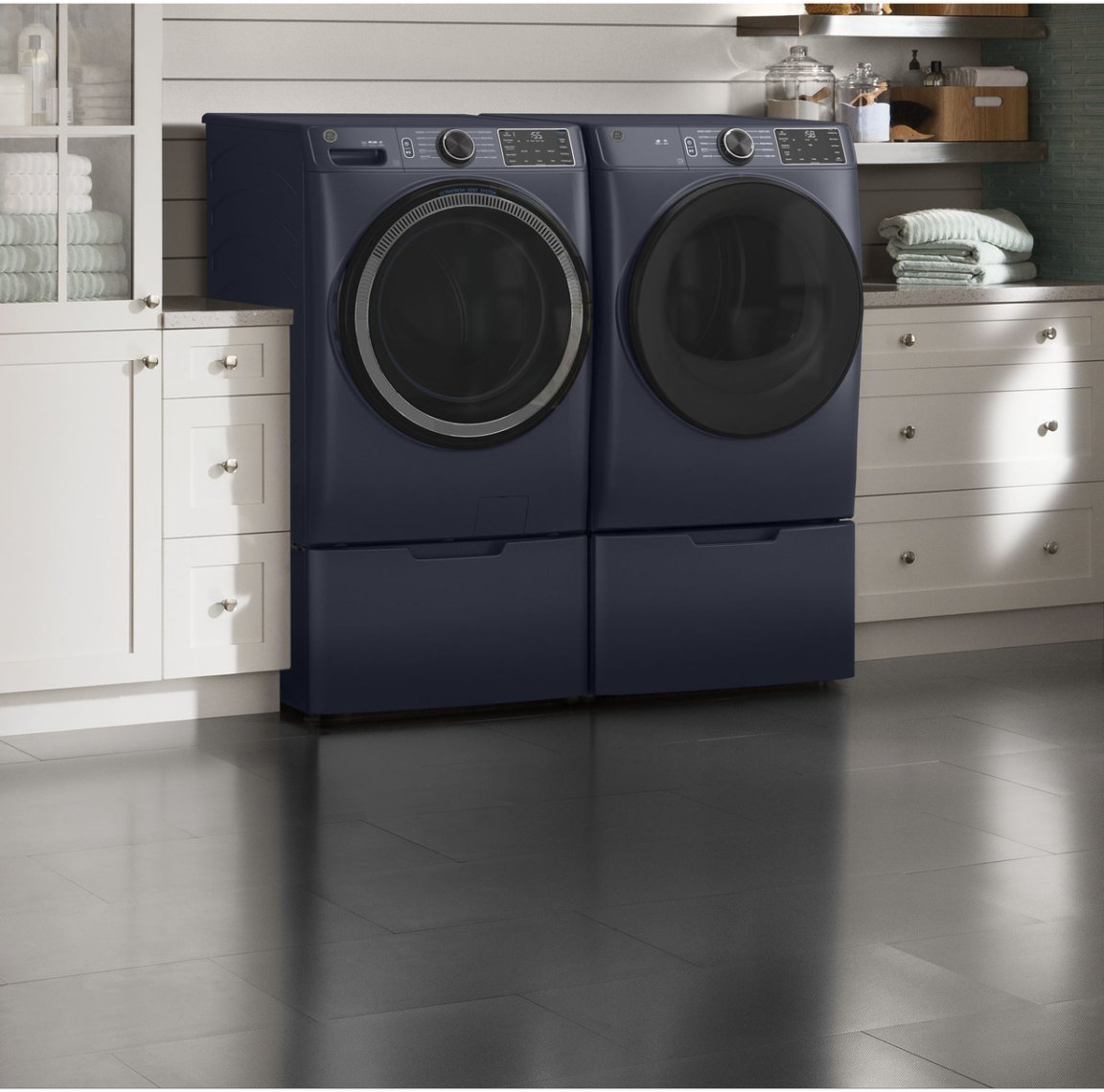 Sapphire blue GE front load washer and dryer in a laundry room with shiplap walls