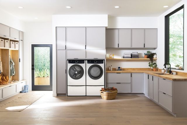 White Electrolux washer and dryer in a large, brightly lit laundry room