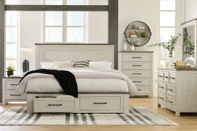 modern bedroom set with white dresser, bed, vanity, and nightstand, in front of a white brick wall