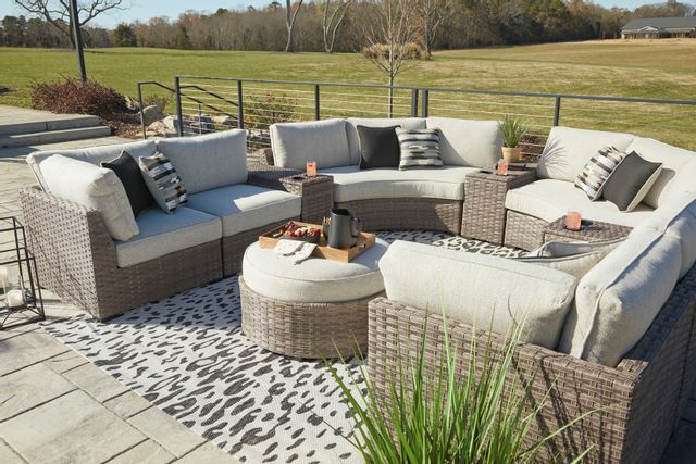 woven patio furniture in a semi circle with light colored cushions