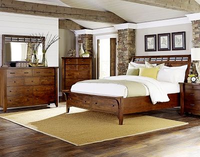 wooden bedroom set containing a matching bed, 2 dressers, and nightstand in a modern rustic bedroom