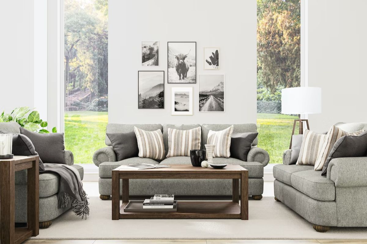 Grey sofa set situated between wood tables in a living room with Americana inspired artwork