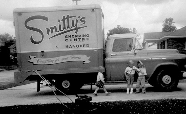 Vintage photo of Smitty's delivery truck with children in front of it