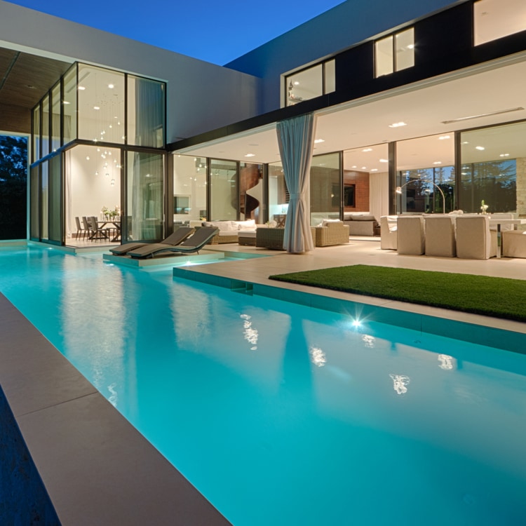 High-end home backyard with large pool and outdoor lighting